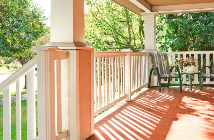 Beautiful covered front porch with wood flooring and white railing