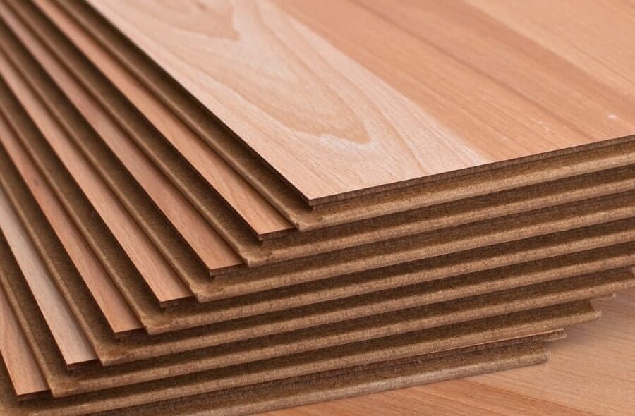 A stack of hardwood flooring planks displayed on a wood surface.