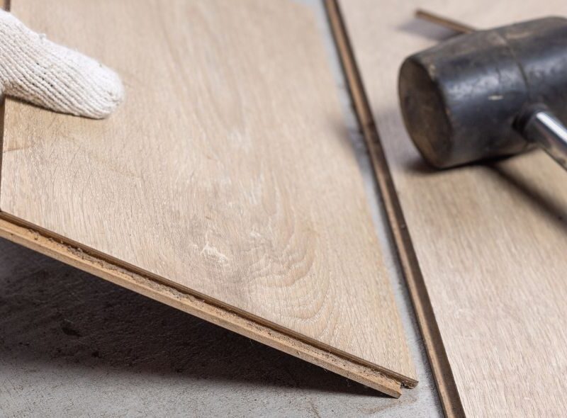 Close up of laminate flooring installation with rubber mallet and wood planks in Missouri